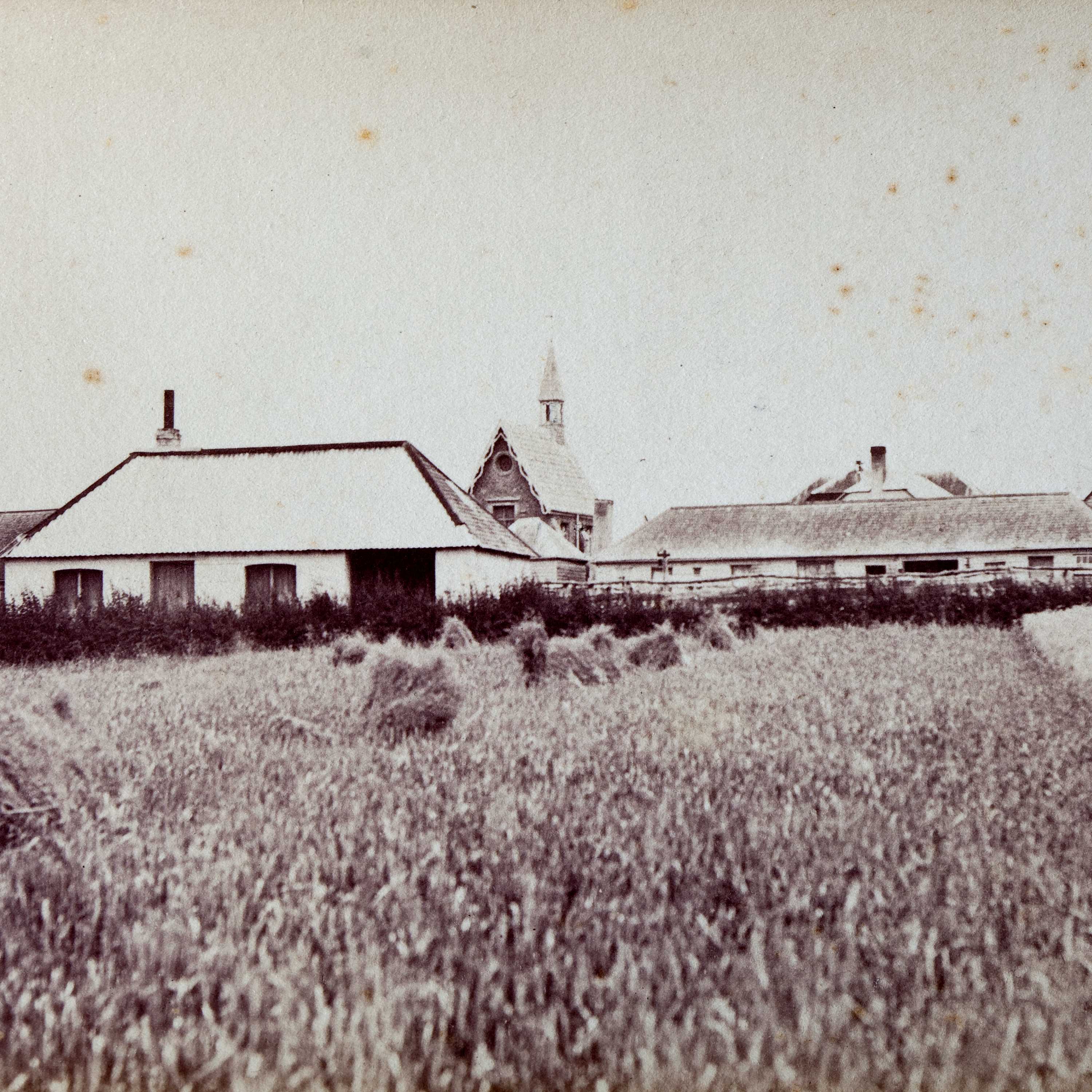 Blacksmith’s shop in the foreground with the convict quarters, carpenter’s hut, sawyer’s hut and chapel visible behind, c1880.