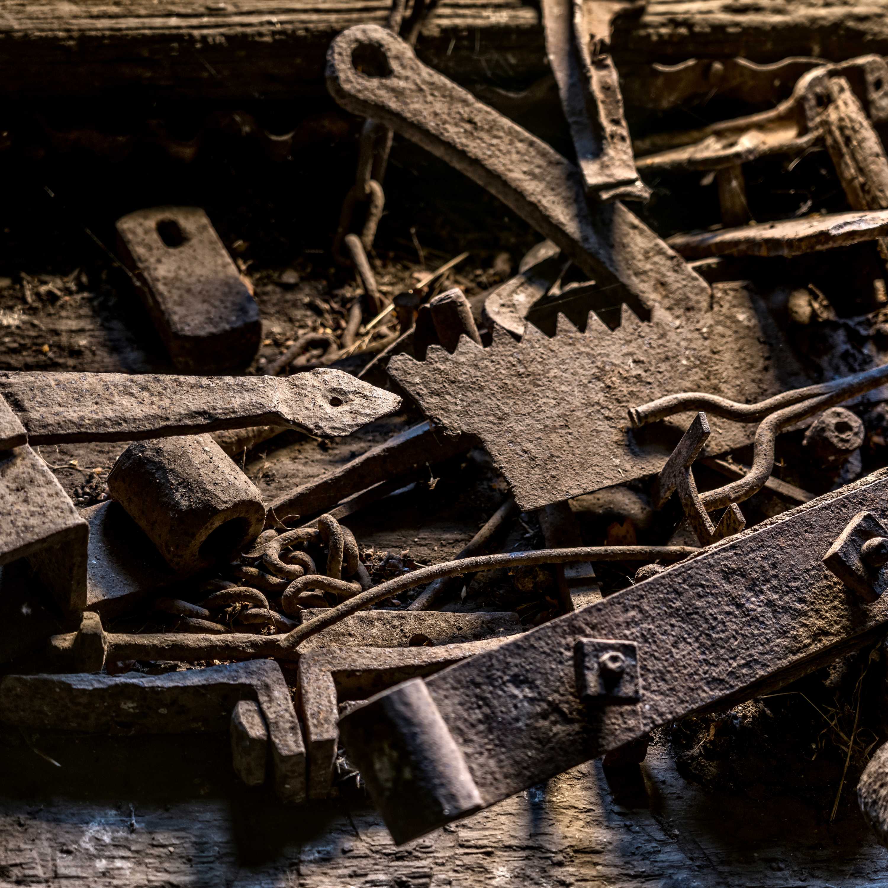 A collection of old metal items that include gate hinges, saw blade, chain and branding iron. Gate hinge is metal branded with W.A. Photo: Rob Burnett.